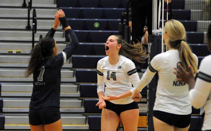 Lake Nona's Anna Pantano (14) celebrates a kill with teammates Jarielys Giraud (7) and Ella McDonald (8) during their victory over Windermere.